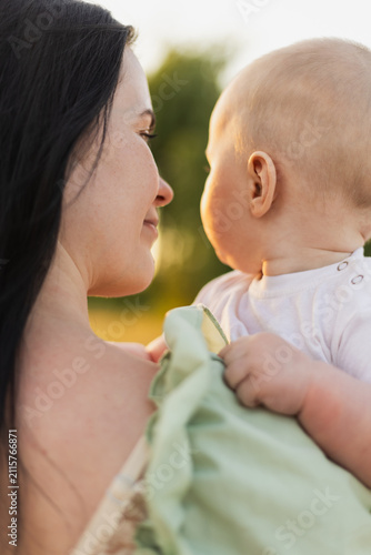Obraz na plátně Mother and baby sharing a tender moment outdoors during golden hour