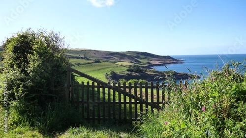 Open wooden gate leads to scenic coastal view