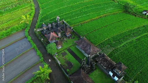 Drone vertical reveal from Balinese temple and rice terraces to Mt. Agung under blue sky, Bali, Indonesia