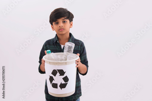 Young boy holding a recycling bin with plastic bottles. (Children) 