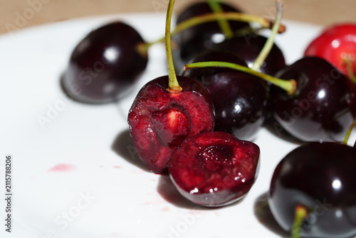 Obraz na płótnie Macro close-up shows sliced dark red cherry with glossy juicy flesh, visible pit