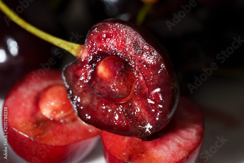 Obraz na plátne Macro close-up shows sliced dark red cherry with glossy juicy flesh, visible pit