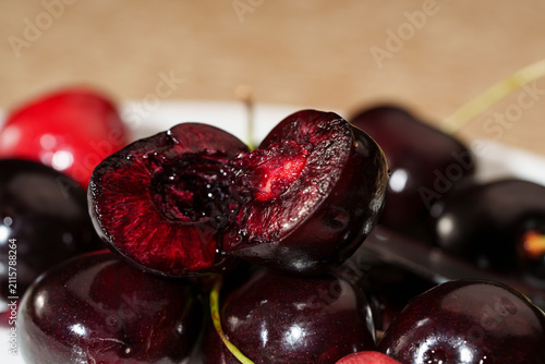 Картината върху платно Close-up of sliced dark red cherry with glossy juicy flesh, visible pit cavity,
