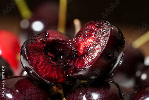 Foto Close-up of sliced dark red cherry with glossy juicy flesh, visible pit cavity,