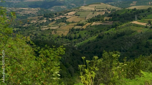 Vista panorámica de un valle de Galicia, con colinas verdes, vegetación abundante y un paisaje natural característico del noroeste de España.