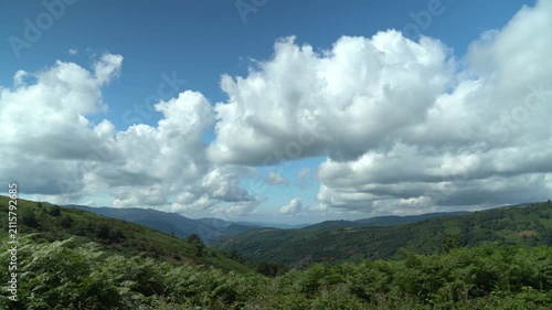 Vista panorámica de un valle de Galicia, con colinas verdes, vegetación abundante y un paisaje natural característico del noroeste de España.