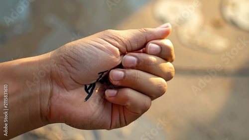 Close-up of hand with 'Justice' written on palm clenching into a fist, symbolizing demand for rights and equality