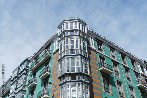 Old residential building facade in Santander, Spain, featuring balconies and dormer windows.