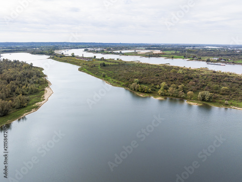 Aerial view of the Millingerwaard nature reserve featuring the winding river Waal and side channel, lush wetlands, and green vegetation in Kekerdom, Gelderland, Netherlands.