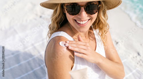 Woman Applying Sunscreen on Shoulder During Sunny Beach Vacation
