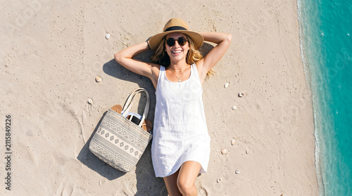 Woman Relaxing on Sandy Beach with Tote Bag During Summer Vacation Top View