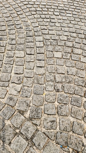 Neatly and symmetrically arranged concrete pavers set amidst a spacious park, bathed in invigorating sunlight—an ideal spot for family recreation and exercise, fostering family bonding and outdoor act