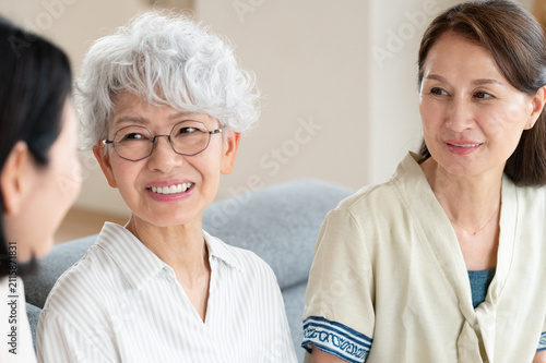 笑顔で会話するシニア女性と家族