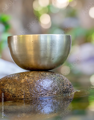 Close-up of a glass of beer with frothy head on wooden table.