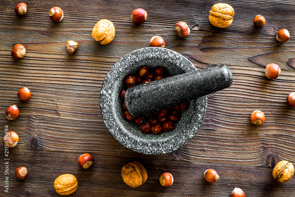 Obraz premium nuts in mortar for making spices in food set on wooden background top view