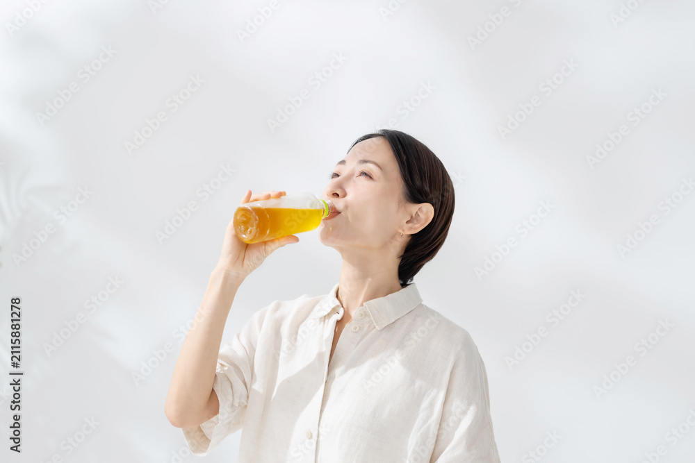 Fototapeta premium ペットボトルのお茶を飲む女性