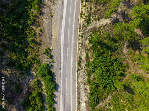 Top down aerial view of new road construction through rugged terrain