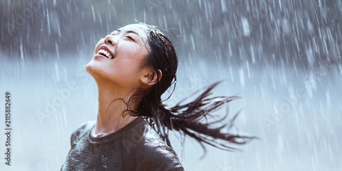 Happy runner enjoying the rain with a smile eyes closed and face lifted towards the sky
