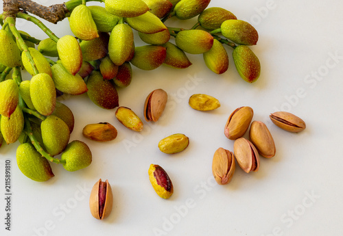 Fresh, natural,and additive-free pistachios are displayed against a white background.The pinkish outer shell of the pistachios is a sign of their freshness and the beginning of their ripening process