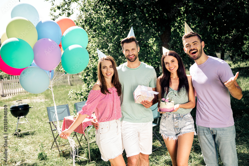 Obraz premium Friends celebrating a summer birthday outdoors with colorful balloons, cake and gifts at a backyard party