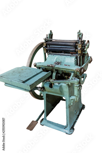 Vintage platen printing press with manual treadle and flywheel isolated on a white background.