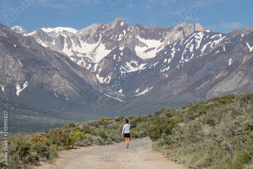 Photography Woman overlooking and walking towards snowy mountains at Crowley Lake