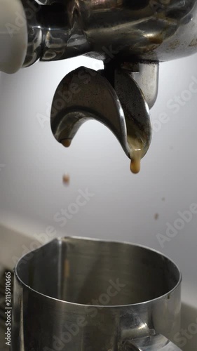 Espresso coffee extraction, barista preparing fresh aromatic drink in modern kitchen setting, close up shot of machine pouring hot liquid into steel cup