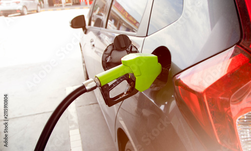 Foto Refueling car with gasoline at petrol station, fuel concept and transportation costGreen fuel nozzle refueling a car at a gas station close up