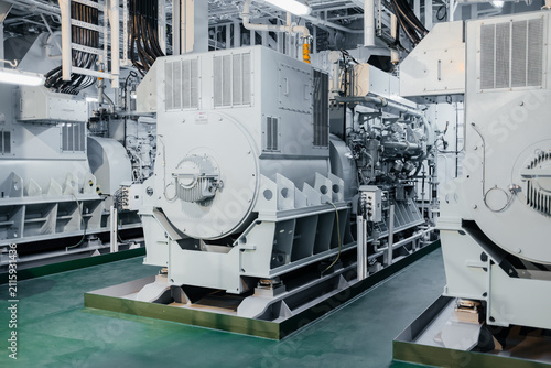 Modern marine diesel generator set inside a ship engine room, heavy industrial equipment and power generation machinery.