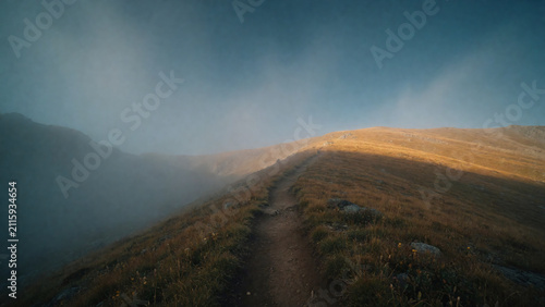 Mountain Trail Emerging Above Valley Fog into Morning Sunlight