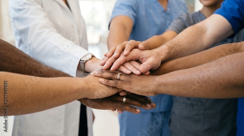 Diverse medical team stacking hands in hospital. Healthcare staff teamwork and patient care in clinic.