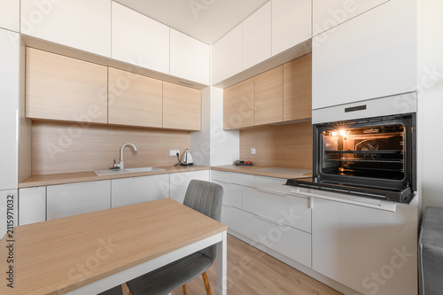 Фотография Contemporary modernist bright kitchen in a minimalist apartment, white kitchen f