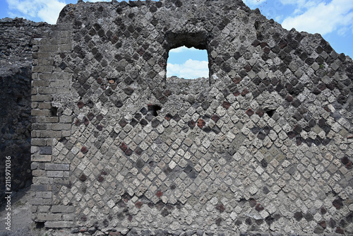 Ancient Wall in Pompeii Archaeological Site with Diamond-Shaped Stone Bricks and Single Window