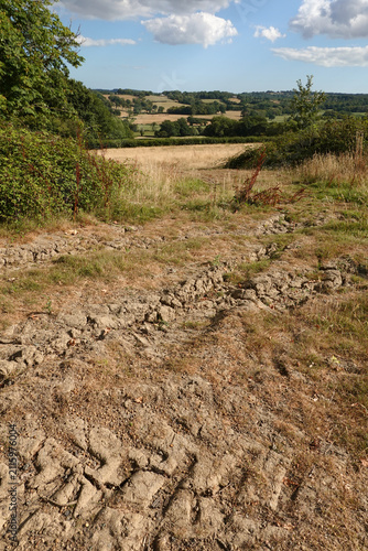 Baked and dry earth during a hot and dry summer with High Weald landscape behind, Burwash, East Sussex, England, United Kingdom, Europe