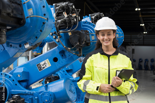 Programming, validation, and monitoring of robotic systems.Portrait of woman engineer using digital tablet connect to robotics arm system for testing and development solutions