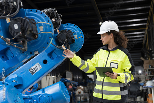 Robotics industry, programming, validation, and monitoring of robotic systems. Woman engineer using digital tablet connect to robotics arm system for testing and development solutions