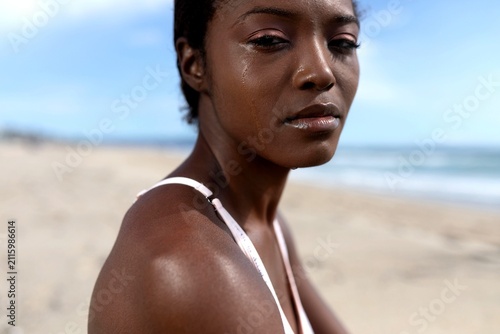 Fotografía Person on a beach with a tear on their cheek, looking contemplative