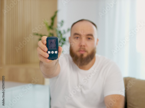 A man displays a glucometer reading of 141 mg dL, highlighting the concern of high blood sugar levels. He addresses the importance of monitoring glucose levels regularly.