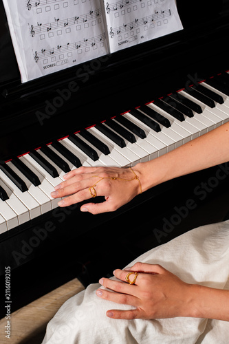 pianist female hands wearing jewelry playing piano
