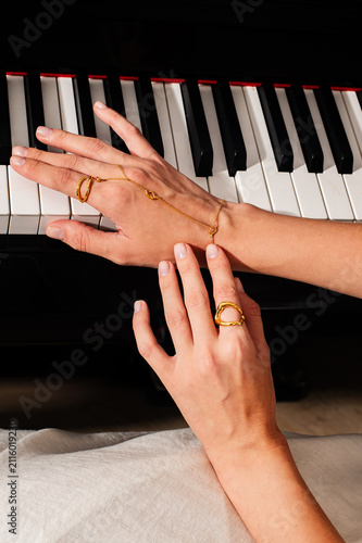 pianist female hands wearing jewelry playing piano
