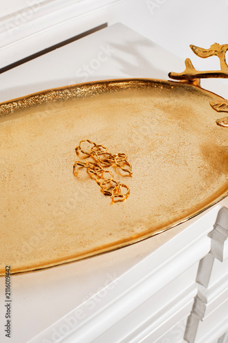 gold jewelry bijouterie  earrings on the gold tray in the white room
