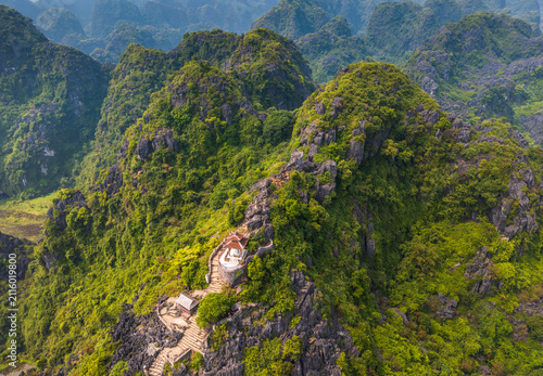 Aerial view of Mua cave with stone stairs winding up the lush limestone karst mountains in Nam Hoa Lu, Ninh Binh, Vietnam.