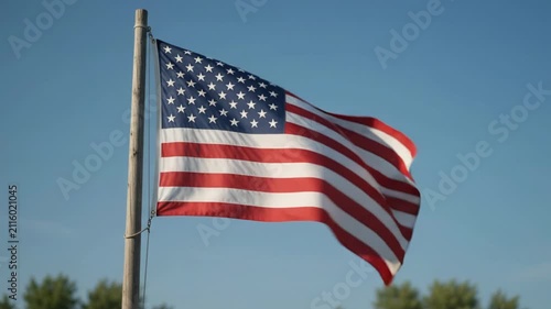 American Flag Gently Waving Against Clear Blue Sky