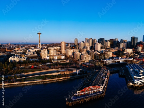 Fotografie Aerial view of Seattle skyline, Space Needle, Elliott Bay waterfront and historic piers at sunset, USA