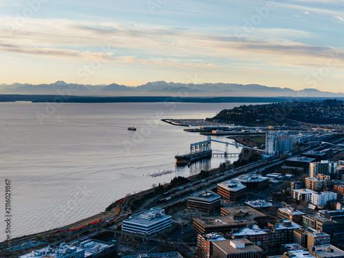 Fotografie Aerial view of Seattle skyline, Space Needle, Elliott Bay waterfront and historic piers at sunset, USA
