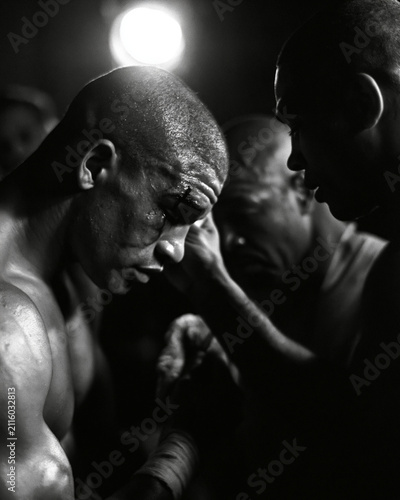 Intense Black and White Portrait of Middleweight Boxer Focused on Pre-Fight Training - Motivation, Teamwork, and Dedication in Combat Sports