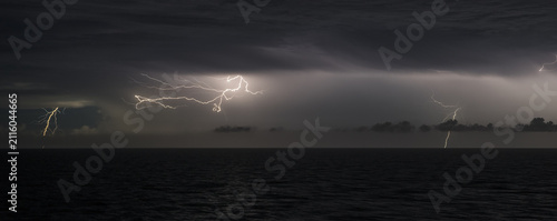 Obraz na plátně Severe weather and climate change, lightning storm over dark ocean at night
