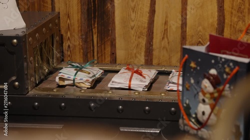Bundles of Christmas mail and letters tied with ribbons move along a vintage conveyor belt into a sorting machine inside Santa Claus workshop