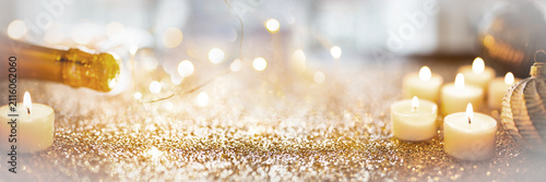 Festive sparkling new years eve background with champage and candle lights.