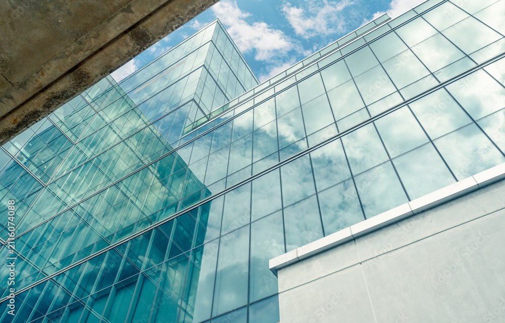 Obraz premium Modern sustainable glass office building with reflective facade. Exterior architecture of corporate headquarters. Energy efficiency, financial business, innovation, ESG, smart city development.
